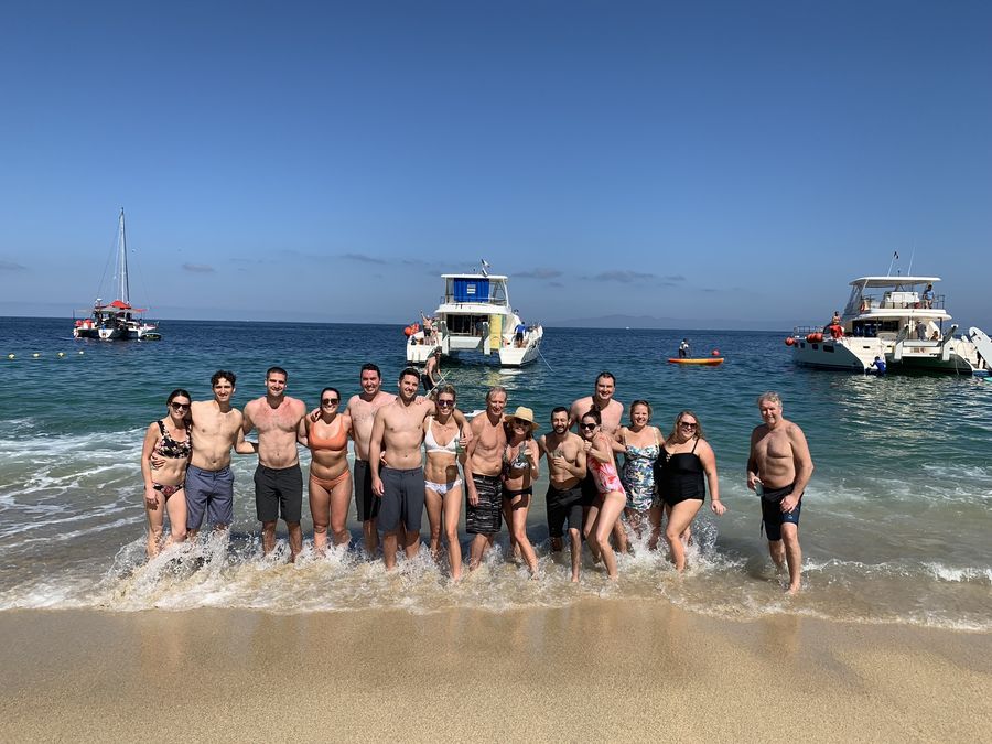 A big group of friends and family celebrating together in the ocean surf